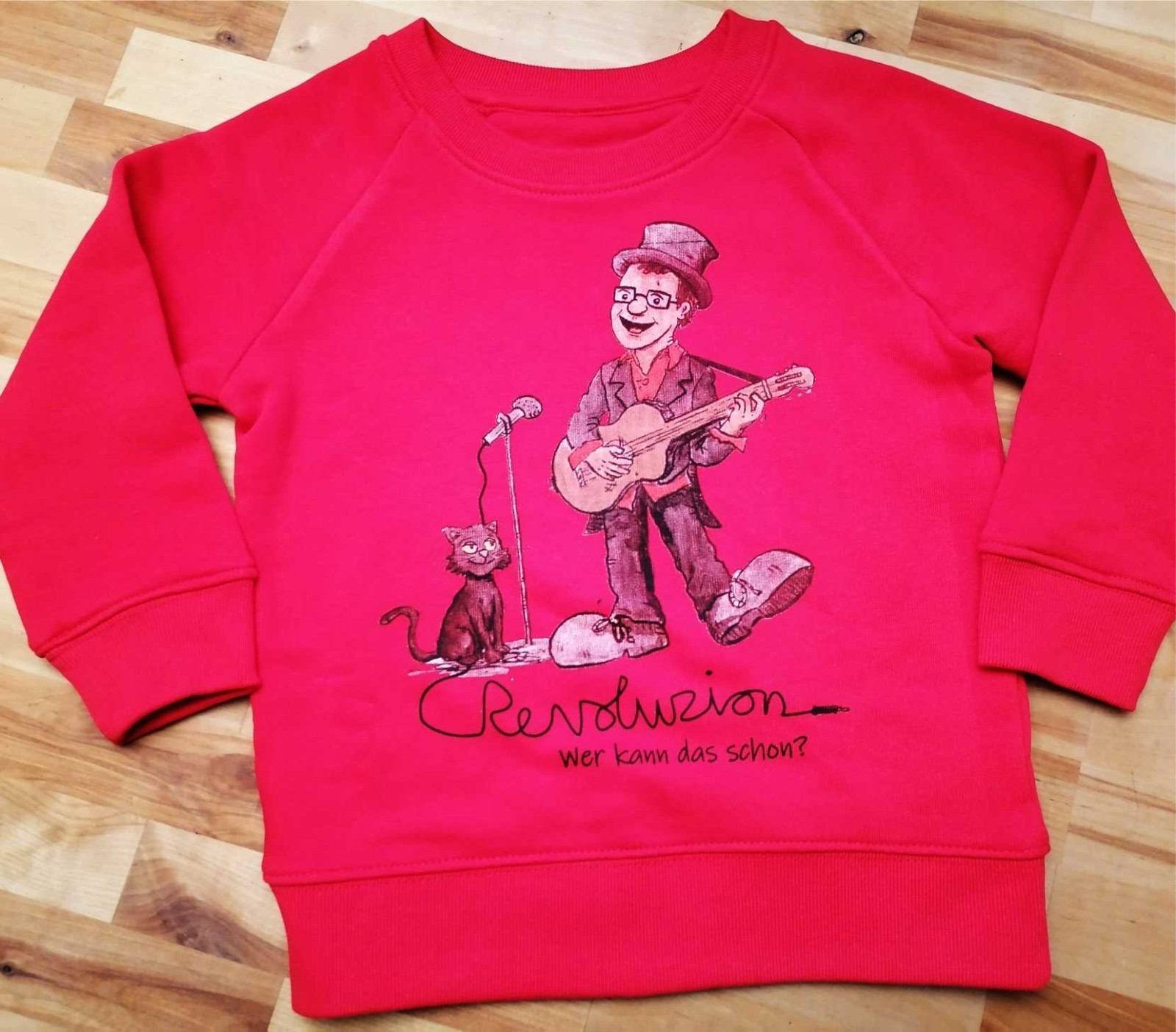 KinderRevoluZionspulli Zu sehen sind ZaPPaloTT & Kater ZaPPsel mit dem Schriftzug. RevoluZion. Wer kann das schon? Auf dem Rücken steht dann. ZaPPaloTT-Revoluzion – Jeder kann das!